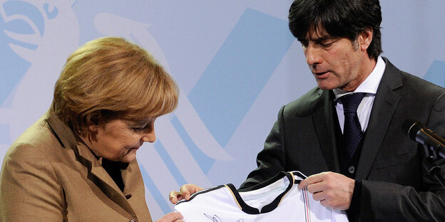 Ein Bild aus besseren Tagen: Löw überreichte 2010 Kanzlerin Merkel ein Nationaltrikot. Ein Bild aus besseren Tagen: Löw überreichte 2010 Kanzlerin Merkel ein Nationaltrikot.