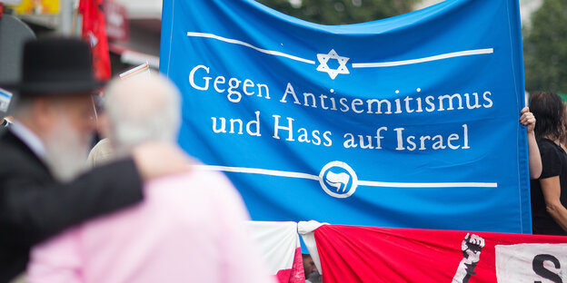 Zwei Menschen stehen vor einem Banner Zwei Menschen stehen vor einem Banner