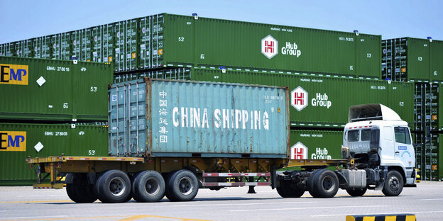 Ein Lastwagen mit der Aufschrift "China Shipping" steht vor befüllten Containern Ein Lastwagen mit der Aufschrift "China Shipping" steht vor befüllten Containern