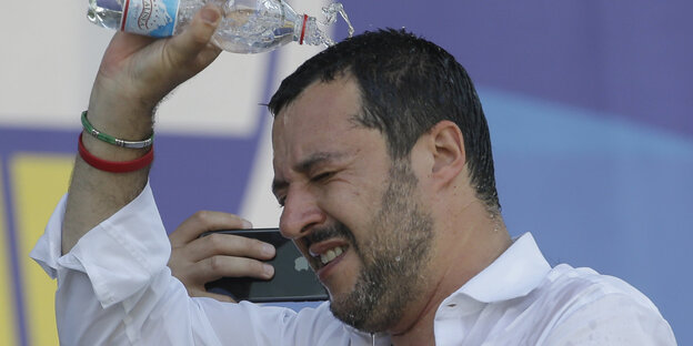 Matteo Salvini, Italiens Innenminister und Chef der Lega Nord, schüttet sich Wasser aus einer Flasche über den Kopf Matteo Salvini, Italiens Innenminister und Chef der Lega Nord, schüttet sich Wasser aus einer Flasche über den Kopf