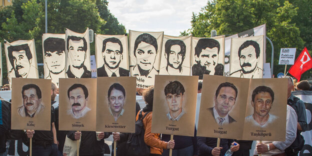 Menschen auf einer Demonstration nach dem Urteil im NSU-Prozess. Sie halten Plakate mit den Bildern der Getöteten in die Höhe Menschen auf einer Demonstration nach dem Urteil im NSU-Prozess. Sie halten Plakate mit den Bildern der Getöteten in die Höhe