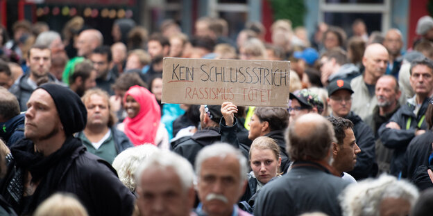 Eine Frau hält auf einer Demonstration unter dem Motto "Fünf Jahre NSU-Prozess - Kein Schlussstrich" ein Schild mit der Aufschrift "Kein Schlussstrich - Rassismus tötet" in die Höhe Eine Frau hält auf einer Demonstration unter dem Motto "Fünf Jahre NSU-Prozess - Kein Schlussstrich" ein Schild mit der Aufschrift "Kein Schlussstrich - Rassismus tötet" in die Höhe