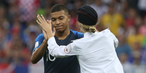 Kylian Mbappé und eine Flitzerin von Pussy Riot Kylian Mbappé und eine Flitzerin von Pussy Riot