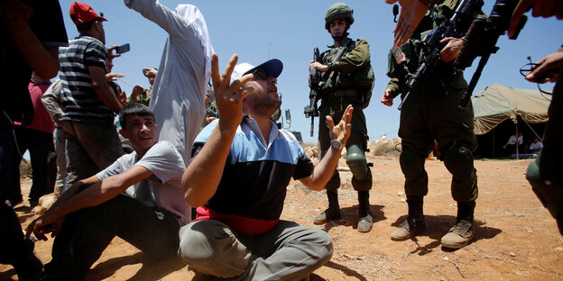 Proteste von Palästinensern gegen jüdische Siedlungen im vergangenen Juni in der Nähe von Hebron. Drum herum stehen israelische Soldaten Proteste von Palästinensern gegen jüdische Siedlungen im vergangenen Juni in der Nähe von Hebron. Drum herum stehen israelische Soldaten