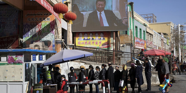 Bewohner laufen durch einen Sicherheitscheck in der Provinz Xinjiang Bewohner laufen durch einen Sicherheitscheck in der Provinz Xinjiang