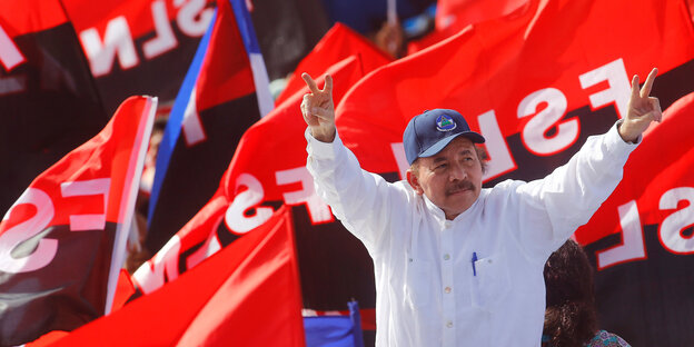 Vor den schwarz-roten Fahnen der FSLN macht Nicaraguas Präsident Daniel Ortega das Victory-Zeichen Vor den schwarz-roten Fahnen der FSLN macht Nicaraguas Präsident Daniel Ortega das Victory-Zeichen