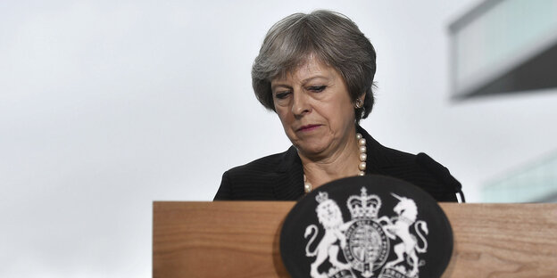 Theresa May mit grimmigem Gesicht hinter einem Stehpult Theresa May mit grimmigem Gesicht hinter einem Stehpult