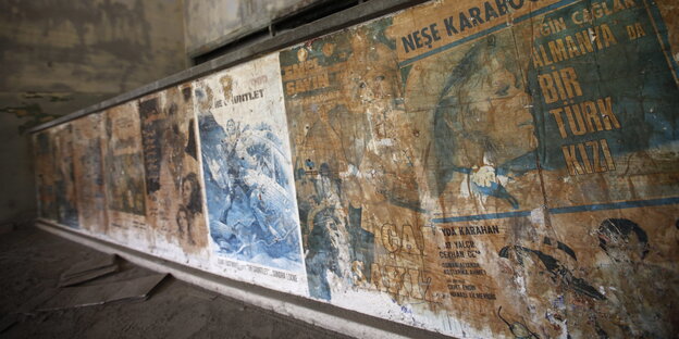 Vergilbte Kino-Poster an einer Wand Vergilbte Kino-Poster an einer Wand
