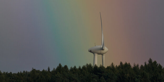 ein Windrad über einem Wald mit Regenbogen darüber ein Windrad über einem Wald mit Regenbogen darüber