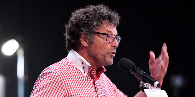 Mann mit Brille an Mikrofon Mann mit Brille an Mikrofon