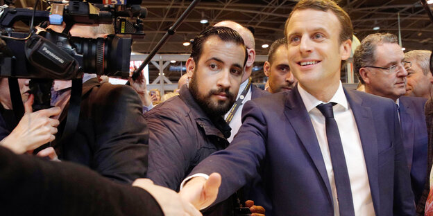 Emmanuel Macron schüttelt eine Hand, sein Bodyguard Alexandre Benalla steht neben ihm Emmanuel Macron schüttelt eine Hand, sein Bodyguard Alexandre Benalla steht neben ihm