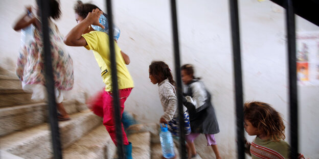 Kleine jemenitische Kinder stürmen in Panik eine Treppe hinauf Kleine jemenitische Kinder stürmen in Panik eine Treppe hinauf