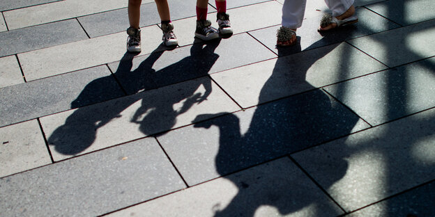 Zwei Kinder werfen in der Sonne einen Schatten Zwei Kinder werfen in der Sonne einen Schatten