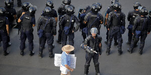 Ein einzelner Demonstrant vor einer Gruppe von Polizisten