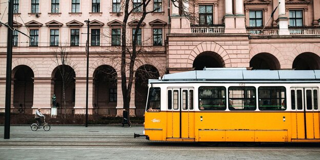 Eine Straßenbahn fährt an einer Radfahrerin vorbei Eine Straßenbahn fährt an einer Radfahrerin vorbei