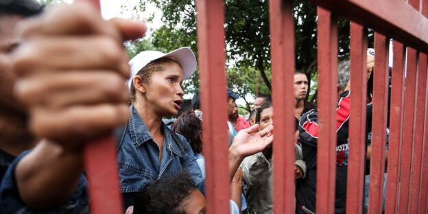 Menschen stehen in Brasilien vor einem Zaun. Menschen stehen in Brasilien vor einem Zaun.