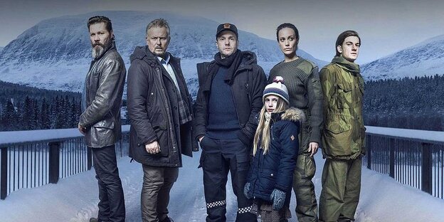 Die Gruppe der Ermittler plus dem verschwundenen Mädchen posieren vor der Kamera in einer Schneelandschaft Die Gruppe der Ermittler plus dem verschwundenen Mädchen posieren vor der Kamera in einer Schneelandschaft