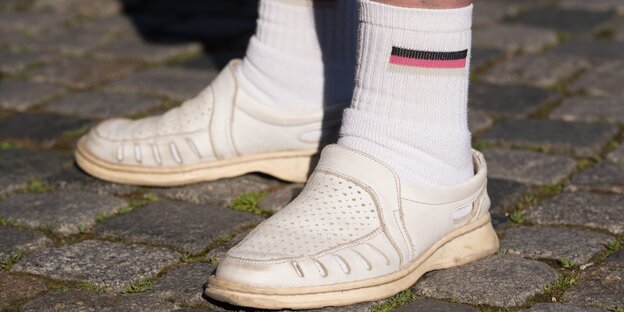 Mann in Schwarz-Rot-Gold-Tennissocken Mann in Schwarz-Rot-Gold-Tennissocken