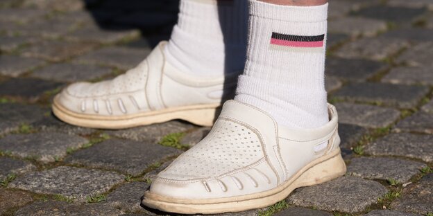 Mann in Schwarz-Rot-Gold-Tennissocken