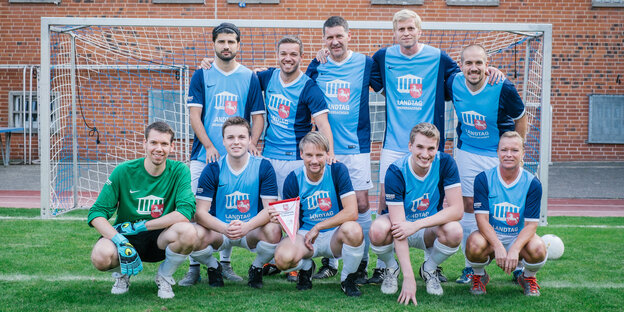 Ein gemischtgeschlechtliches Fußballteam in blauen Triktos. Ein gemischtgeschlechtliches Fußballteam in blauen Triktos.