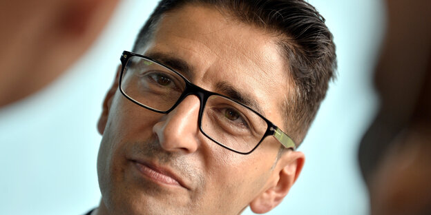 Efgani Dönmez trägt eine Brille und schaut in das Gesicht seines Gegenübers Efgani Dönmez trägt eine Brille und schaut in das Gesicht seines Gegenübers