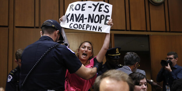 Frau hält ein Protestschild gegen Kavanaugh hoch Frau hält ein Protestschild gegen Kavanaugh hoch