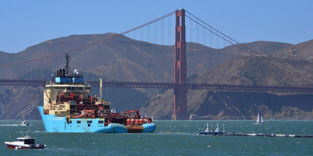 An der Golden Gate Bridge von San Francisco schleppt ein Schiff ein langes Rohr hinter sich her An der Golden Gate Bridge von San Francisco schleppt ein Schiff ein langes Rohr hinter sich her
