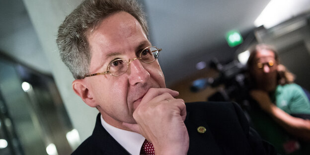 Verfassungsschutzchef Hans-Georg Maaßen hält seine Hand nachdenklich an den Mund Verfassungsschutzchef Hans-Georg Maaßen hält seine Hand nachdenklich an den Mund