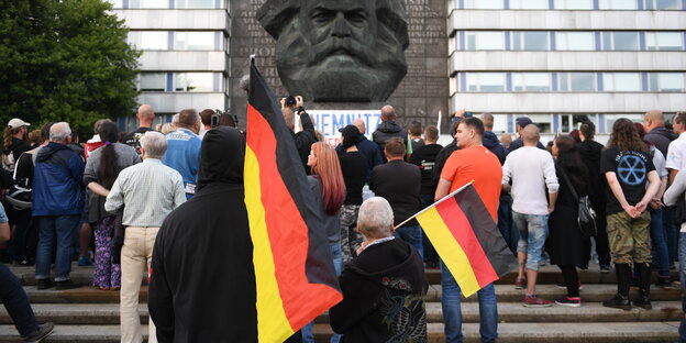 Menschen mit Deutschlandfahnen vor dem Marx-Kopf in Chemnitz Menschen mit Deutschlandfahnen vor dem Marx-Kopf in Chemnitz