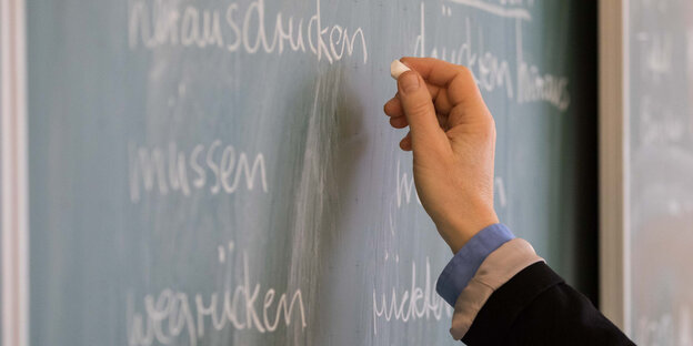 Eine Lehrerin der Oberschule an der Ronzelenstraße steht in einem Klassenraum an einer Tafel und schreibt Eine Lehrerin der Oberschule an der Ronzelenstraße steht in einem Klassenraum an einer Tafel und schreibt