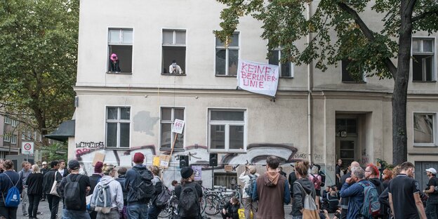 Menschen stehen vor dem besetzten Haus