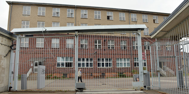 Vor einem Gebäude steht ein Gitter Vor einem Gebäude steht ein Gitter