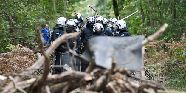 Vermummte Polizisten im Wald