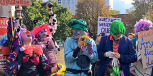 Clowns, einer hebt eine Banane hoch Clowns, einer hebt eine Banane hoch