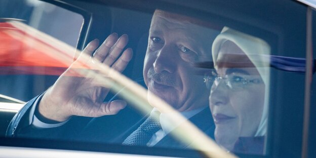 Erdoğan und seine Frau Emine Erdoğan sitzen in einem Auto, er winkt Erdoğan und seine Frau Emine Erdoğan sitzen in einem Auto, er winkt