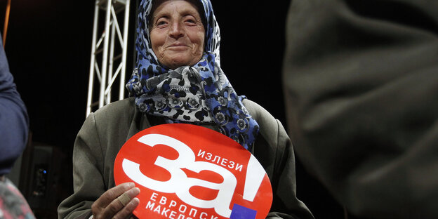 Eine Frau hält ein Plakat mit der Aufschrift «Kommt raus für ein europäisches Mazedonien». Eine Frau hält ein Plakat mit der Aufschrift «Kommt raus für ein europäisches Mazedonien».