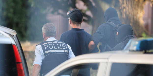 Ein Mann wird von der Polizei abgeführt Ein Mann wird von der Polizei abgeführt