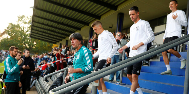 Nationalelf-Trainer Jogi Löw betritt mit seinen Spielern das Stadion auf dem Wufplatz in Berlin. Im Hintergrund jubeln Fans der Mannschaft zu. Nationalelf-Trainer Jogi Löw betritt mit seinen Spielern das Stadion auf dem Wufplatz in Berlin. Im Hintergrund jubeln Fans der Mannschaft zu.