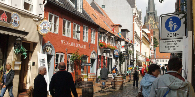 Menschen gehen durch die Flensburger Altstadt. Menschen gehen durch die Flensburger Altstadt.