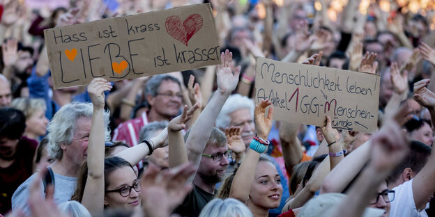 Menschen halten auf der unteilbar-Demo Schilder hoch, auf einem steht: Hass ist krass, Liebe ist krasser Menschen halten auf der unteilbar-Demo Schilder hoch, auf einem steht: Hass ist krass, Liebe ist krasser