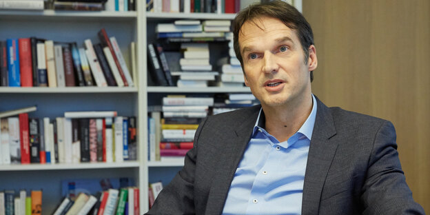 Klaus Brinkbäumer sitzt vor einem Bücherregal an einem Schreibtisch Klaus Brinkbäumer sitzt vor einem Bücherregal an einem Schreibtisch