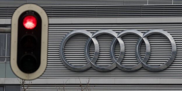 Eine rote Ampel neben einem Audi-Logo Eine rote Ampel neben einem Audi-Logo