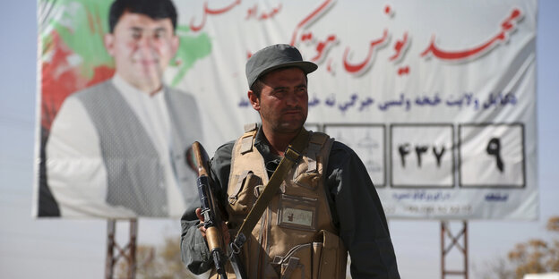 Vor einem Checkpoint in Kabul steht ein bewaffneter Polizist Vor einem Checkpoint in Kabul steht ein bewaffneter Polizist