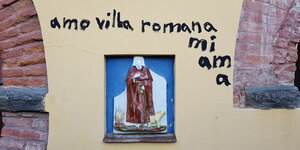 „Amo villa romana mi ama“ steht an der Wand der Villa Romana