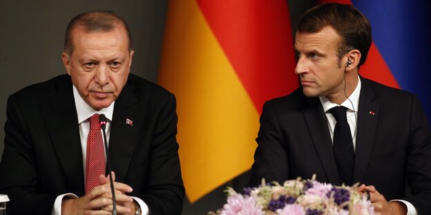 Erdogan sitzt neben Frankreichs Präsident Macron an einem Tisch mit Mikrofonen bei einer Pressekonferenz Erdogan sitzt neben Frankreichs Präsident Macron an einem Tisch mit Mikrofonen bei einer Pressekonferenz