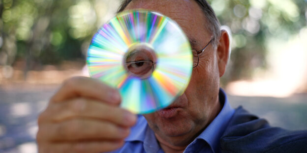 Norbert Walter-Borjans hält sich eine CD vors Gesicht Norbert Walter-Borjans hält sich eine CD vors Gesicht