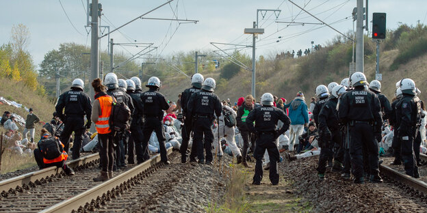 Aktivisten und Polizisten stehen auf einem Gleis Aktivisten und Polizisten stehen auf einem Gleis