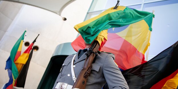 Soldat des Wachbatallions mit einer Fahne im Gesicht Soldat des Wachbatallions mit einer Fahne im Gesicht