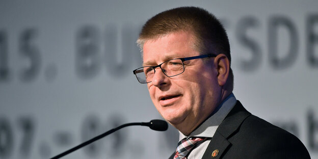 Thomas Haldenwang steht im Anzug an einem Mikrofon Thomas Haldenwang steht im Anzug an einem Mikrofon
