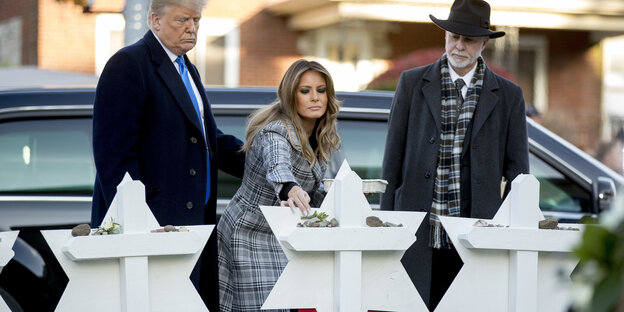 Donald Trump steht mit seiner Frau Melania und einem Rabbi am Gedenkort für die in Pittsburgh getöteten Menschen Donald Trump steht mit seiner Frau Melania und einem Rabbi am Gedenkort für die in Pittsburgh getöteten Menschen